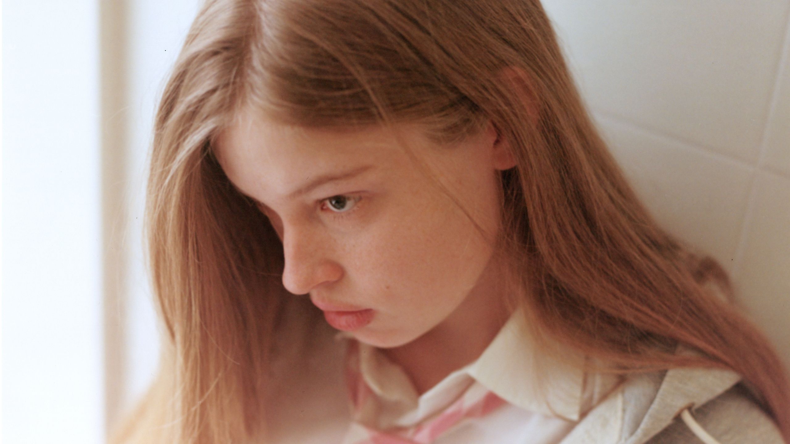 Closeup portrait of Vivian looking away from viewer while wearing a gingham tie and white collared shirt.