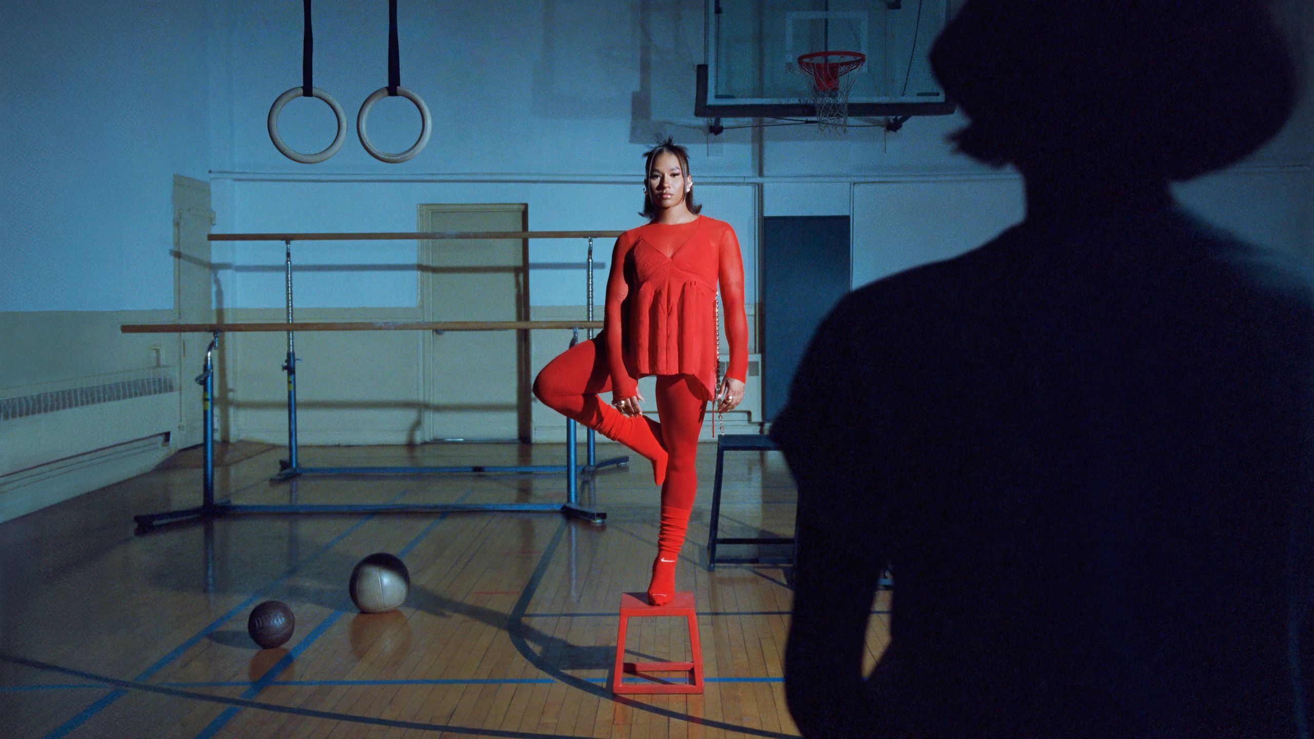 Portrait of the gymnast and Olympic Medalist Jordan Chiles standing on a stool in a gym.