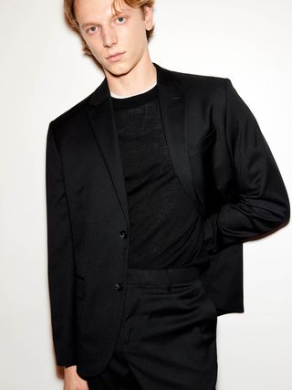 Image may contain Clothing Formal Wear Suit Blazer Coat Jacket Tuxedo Adult and Person